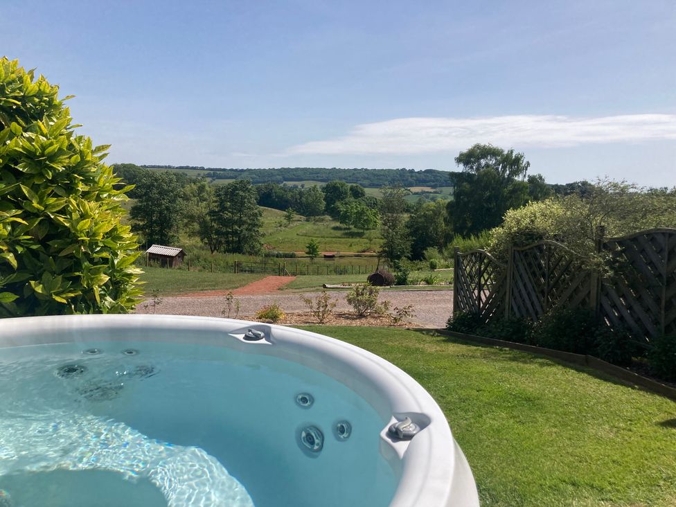 A hot tub overlooking a green landscape at Chestnut Lodge in Worcester