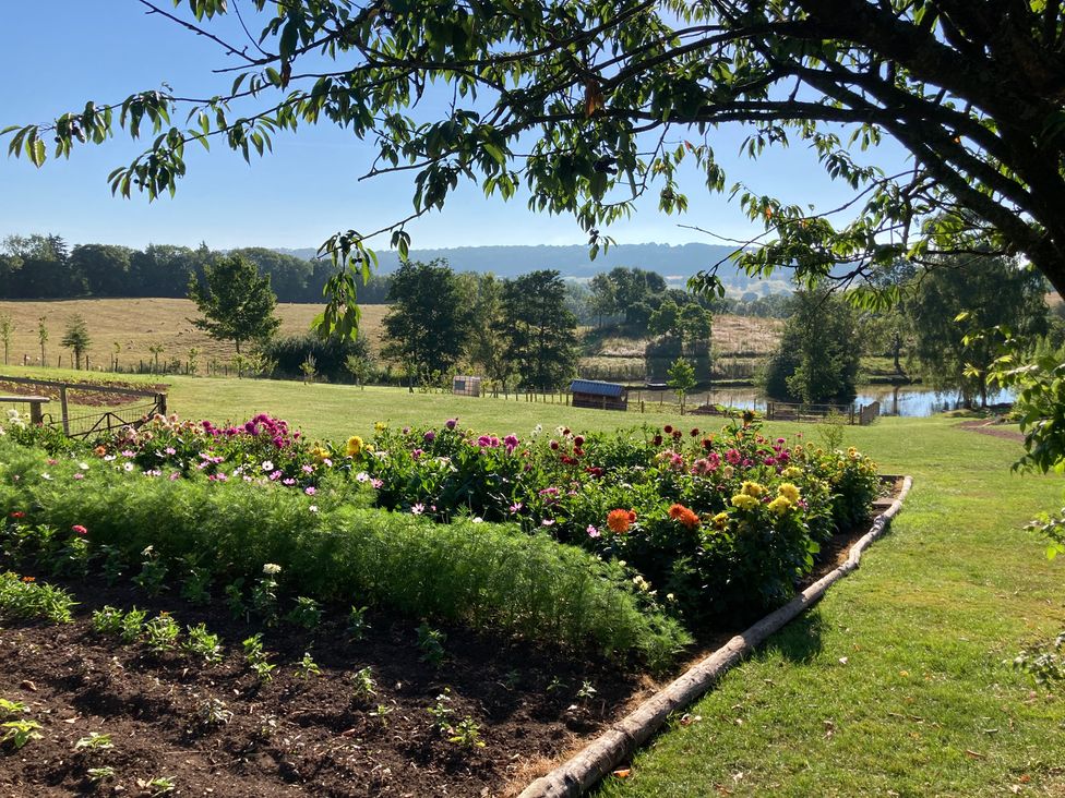 A garden with a flower bed and pond at Chestnut Lodge in Worcester