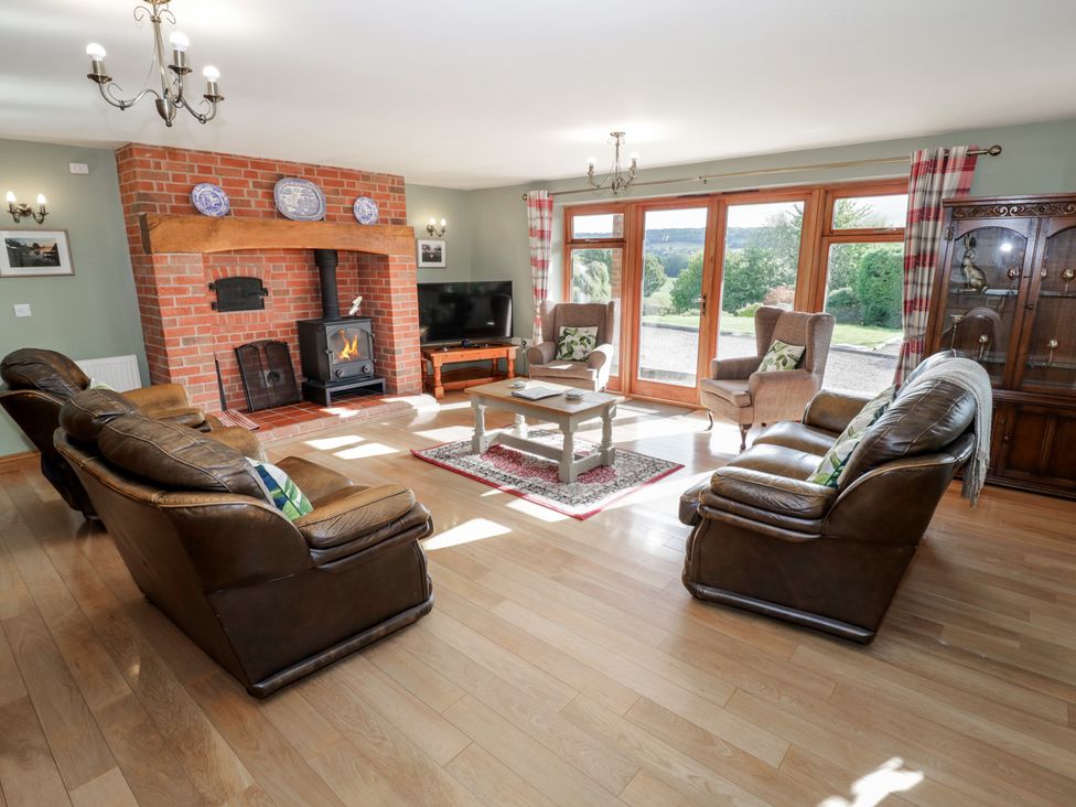 A living room with a fireplace and sofa at Chestnut Lodge in Worcester