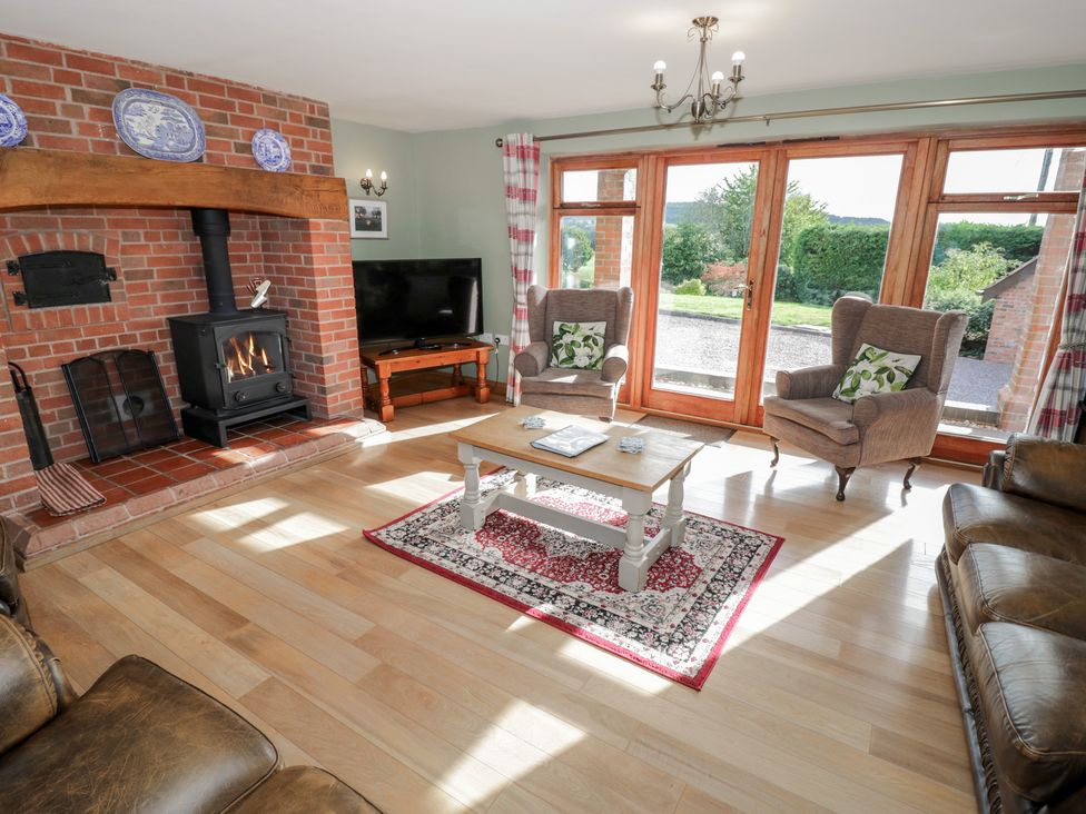 A living room with a fireplace and television at Chestnut Lodge in Worcester