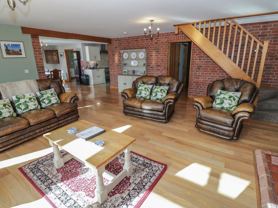 A living room with two sofas, a coffee table, and a staircase at Chestnut Lodge in Worcester