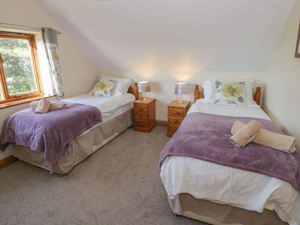 A bedroom with two beds and bedside tables at Chestnut Lodge in Worcester