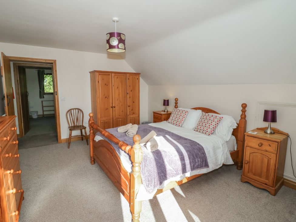 A bedroom with a bed and wardrobe at Chestnut Lodge in Worcester
