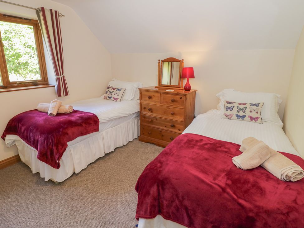 A bedroom with twin beds and a chest of drawers at Chestnut Lodge in Worcester