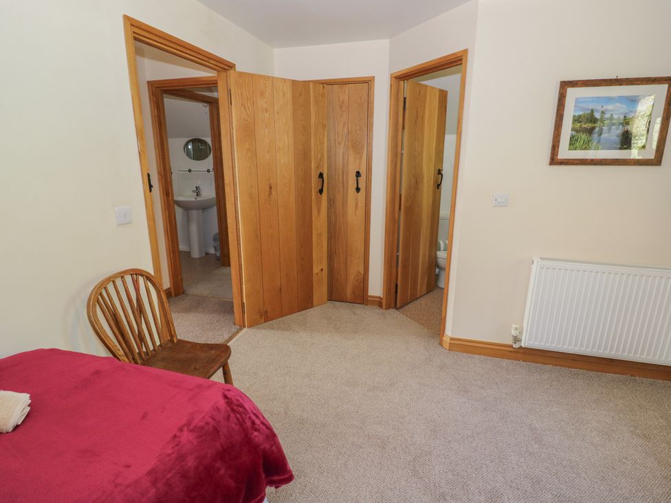 A bedroom with doors leading to bathroom at Chestnut Lodge Worcester