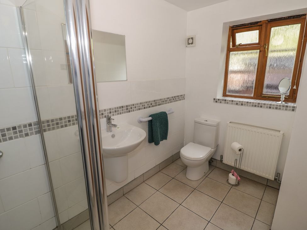 A bathroom featuring a toilet, washbasin, and shower at Chestnut Lodge in Worcester