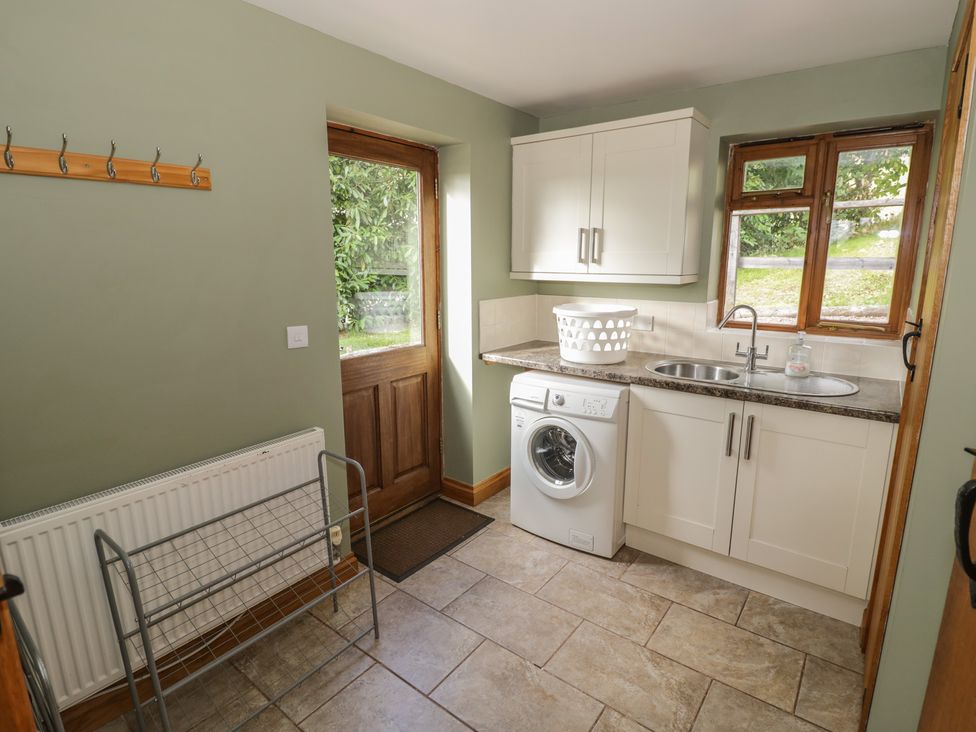 A laundry room with a washing machine and sink at Chestnut Lodge in Worcester