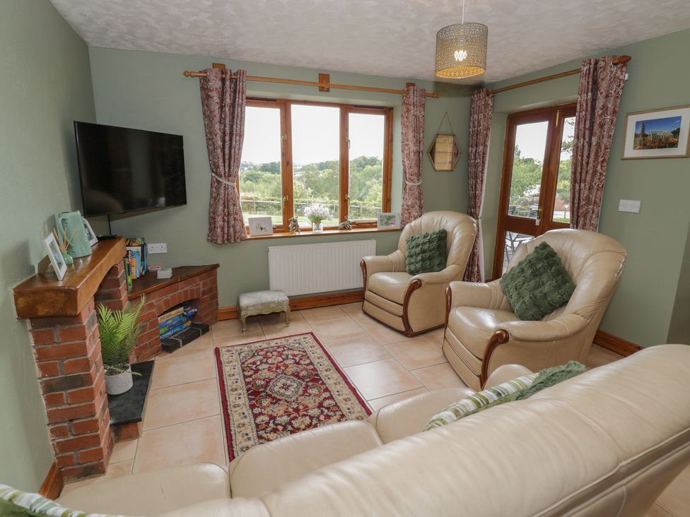 A living room with a television and armchairs at Kingfisher in Worcester
