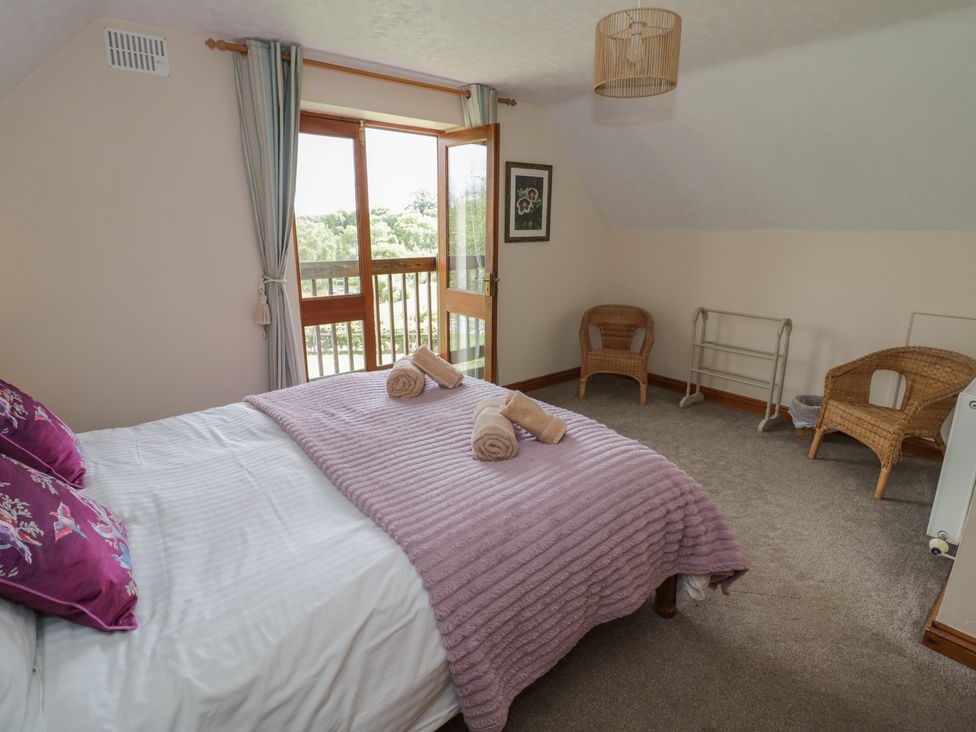 A bedroom with a bed and chairs at Kingfisher in Worcester