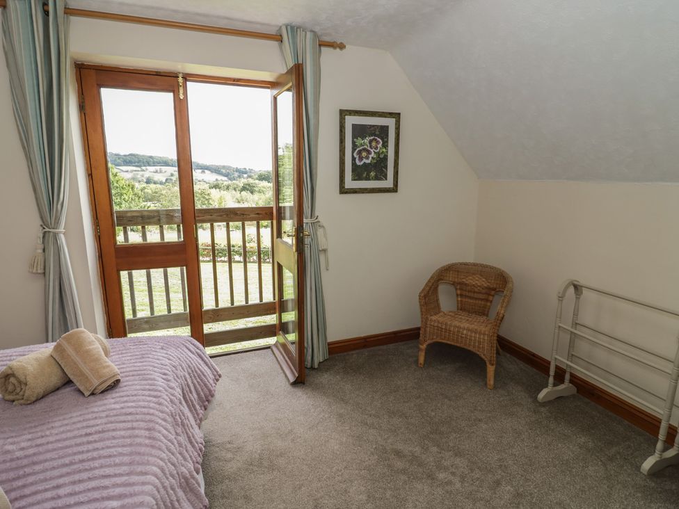 A bedroom with a bed and wicker chair at Kingfisher in Worcester