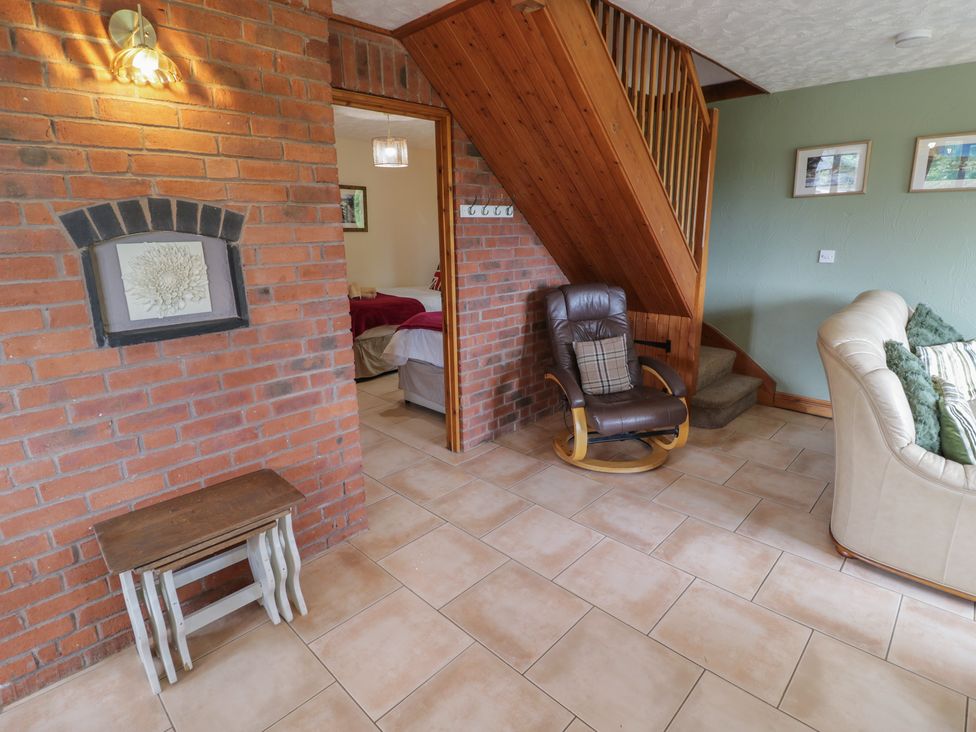 A living room with a staircase and furniture at Kingfisher in Worcester