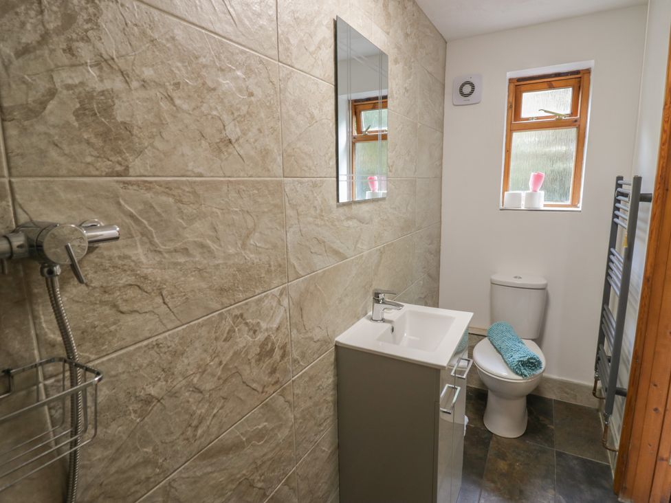 A bathroom with a shower, sink, toilet and window at Kingfisher in Worcester