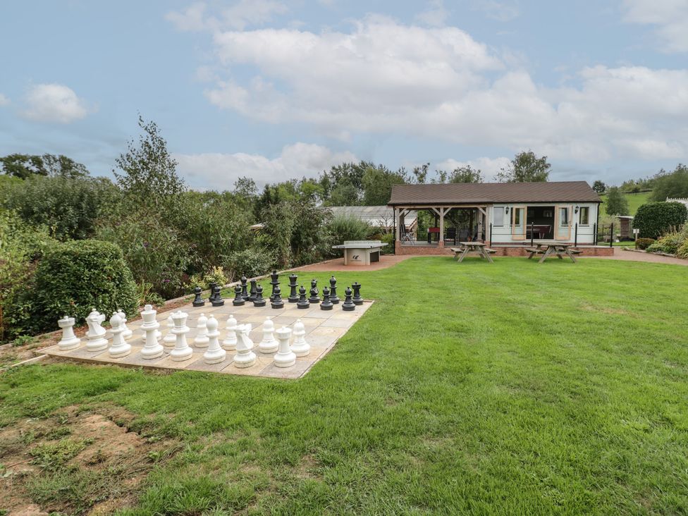 A garden with a large chess set and a cabin at Kingfisher in Worcester