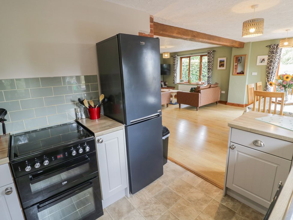 A kitchen with stove and refrigerator leading to a living area at Heron in Worcester