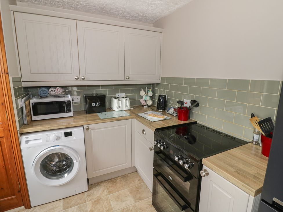 A kitchen featuring a washing machine, oven, and microwave at Heron in Worcester