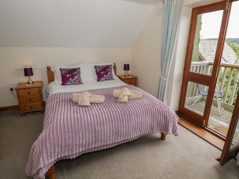 A bedroom with a bed and balcony door at Heron in Worcester