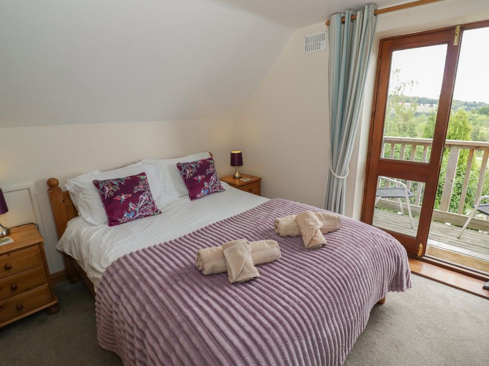 A bedroom with a double bed and a balcony at Heron in Worcester