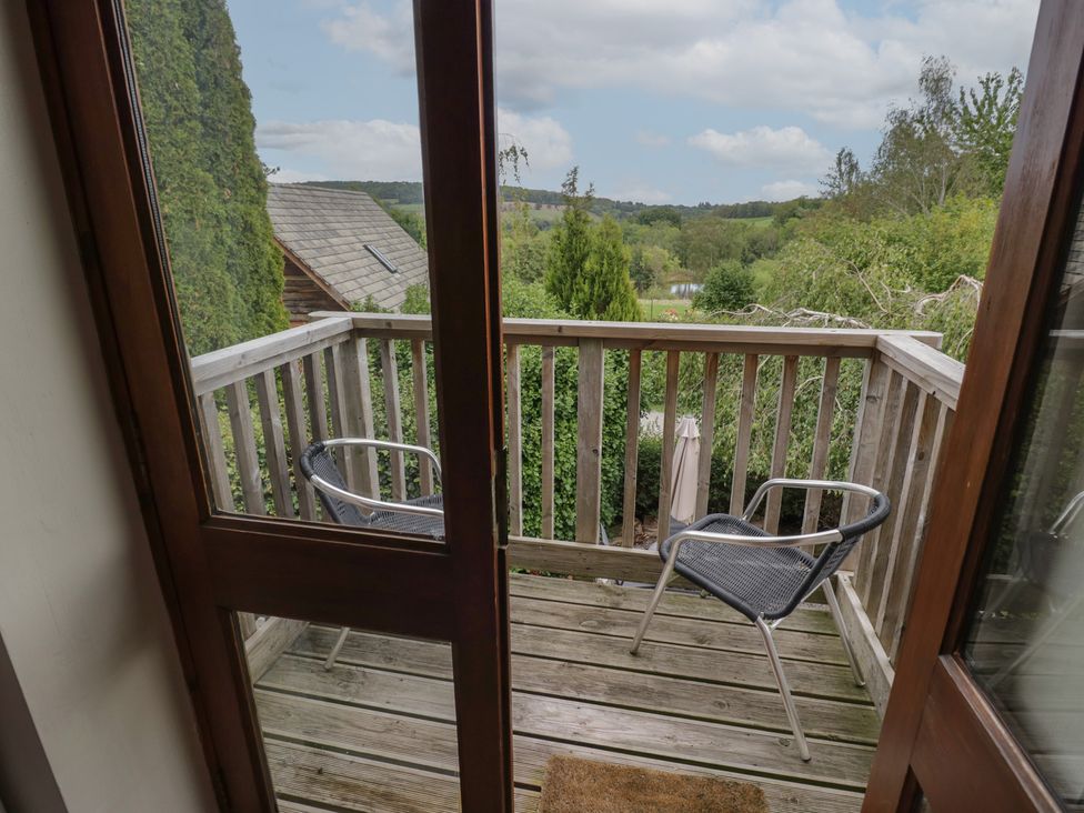 A balcony with chairs and wooden railing at Heron in Worcester