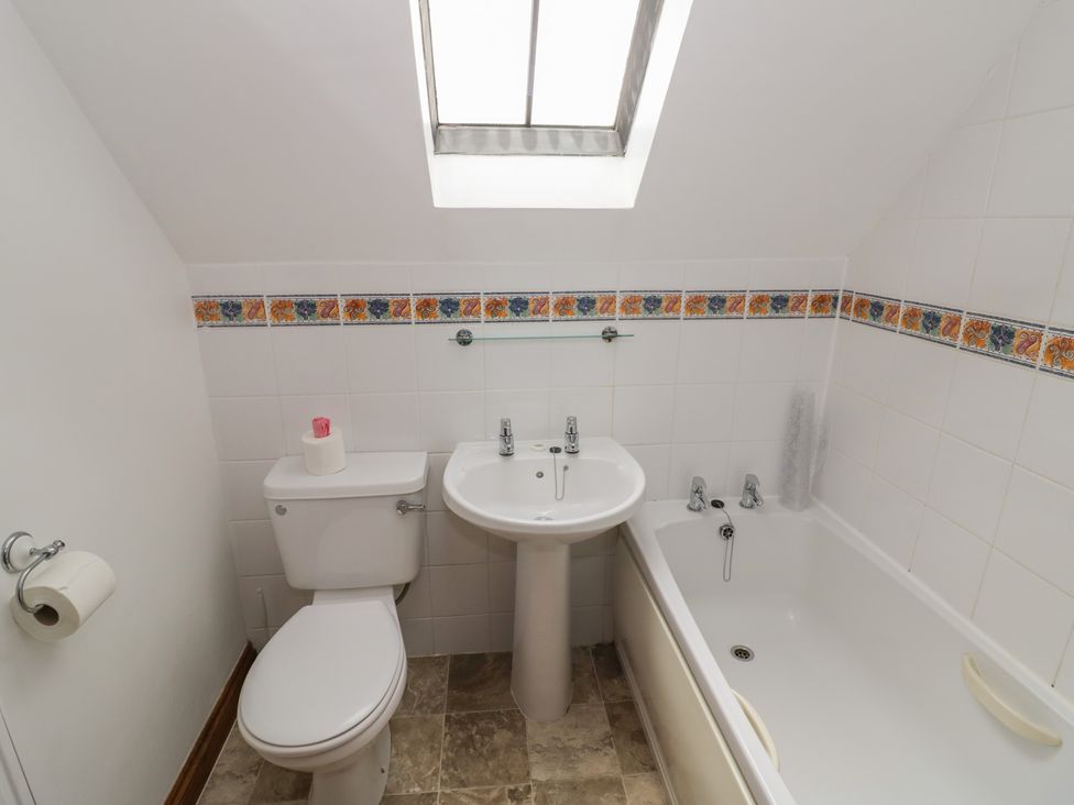 A bathroom with a toilet, sink, and bathtub at Heron in Worcester