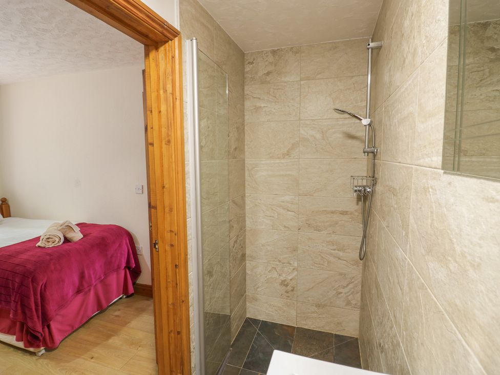 A bathroom with a shower and a bed at Heron in Worcester