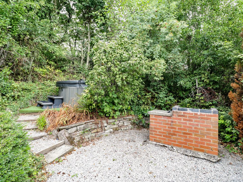 A garden with a hot tub and brick wall at Heron in Worcester
