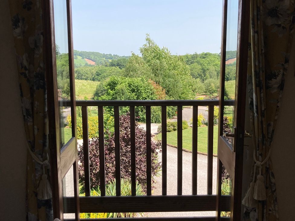 A view from a window showing a garden and trees at Woodpecker in Worcester