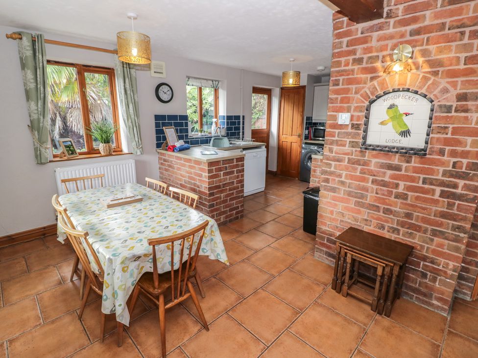 A kitchen with a dining table and appliances at Woodpecker in Worcester