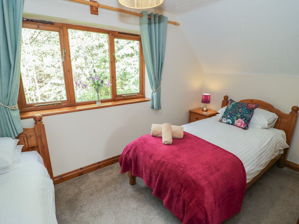 A bedroom with two beds and a window at Woodpecker in Worcester