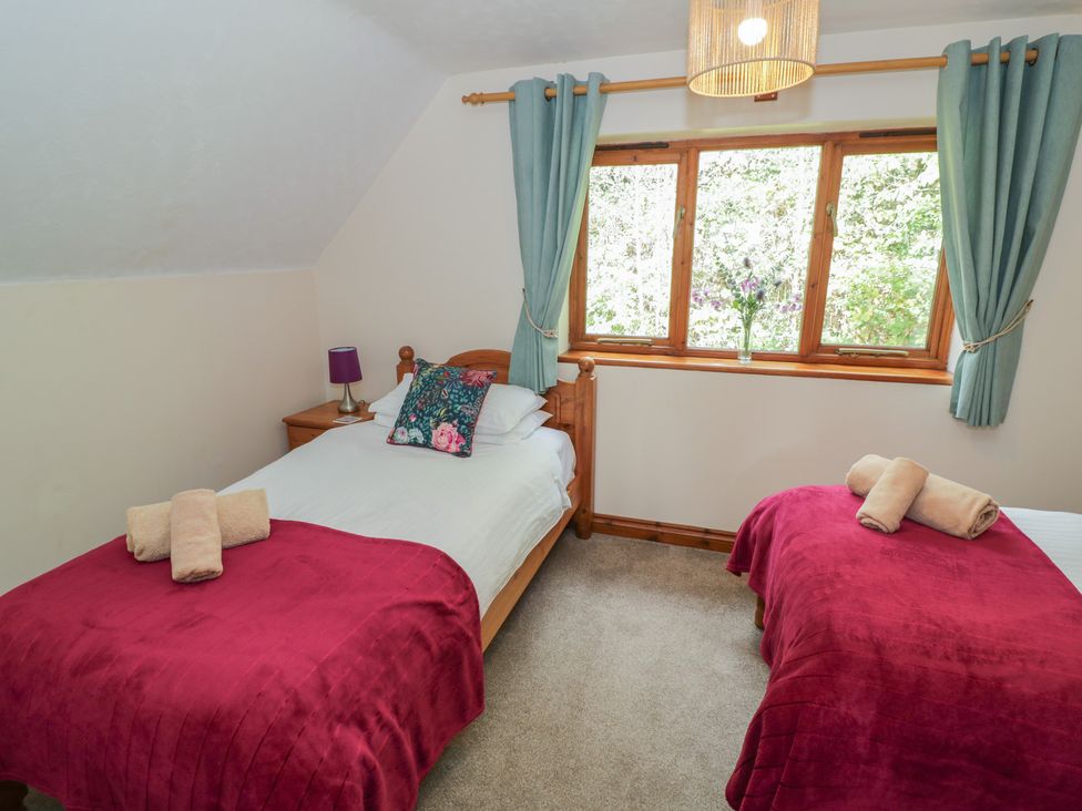 A bedroom with two beds and a window at Woodpecker in Worcester