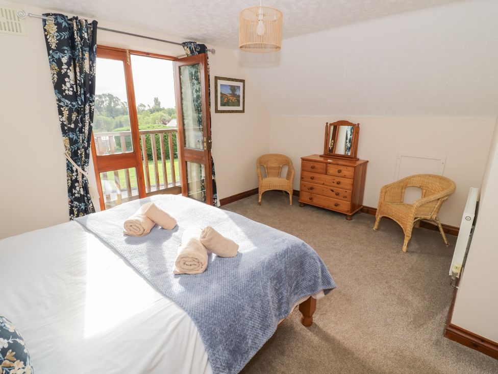 A bedroom with a bed and dressing table at Woodpecker in Worcester