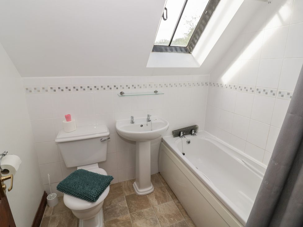 A bathroom with a sink, toilet, and bathtub at Woodpecker in Worcester