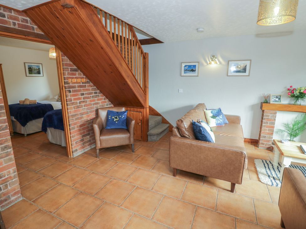 A living room with a sofa and armchair at Woodpecker in Worcester