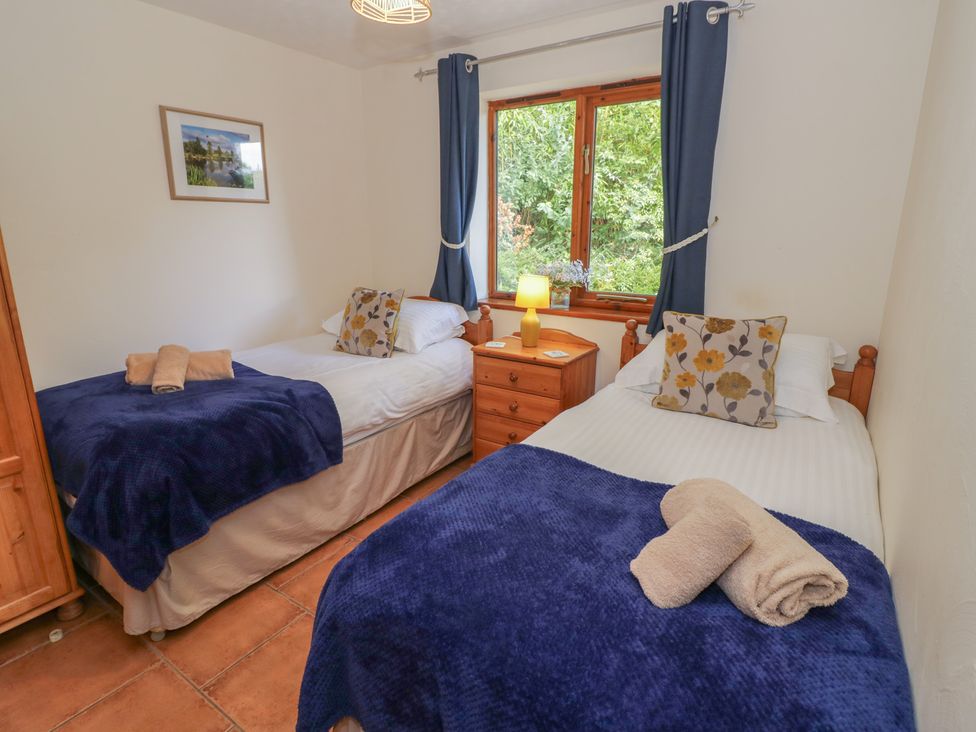 A bedroom with two single beds and a window at Woodpecker in Worcester