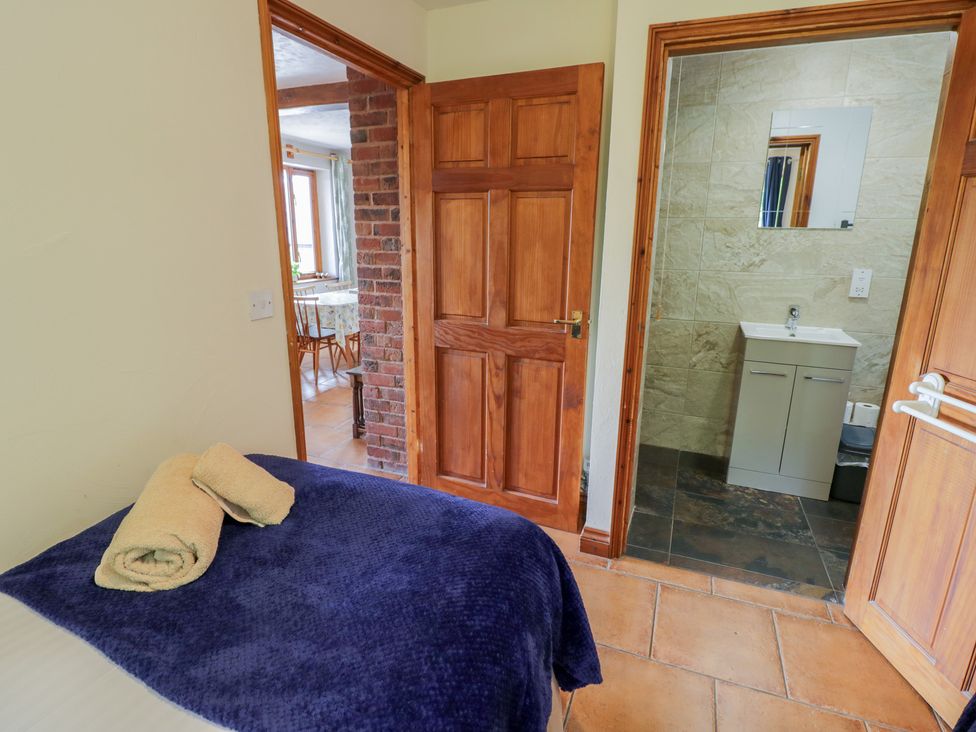 A bedroom with a bed and towels with a door leading to a bathroom at Woodpecker Worcester