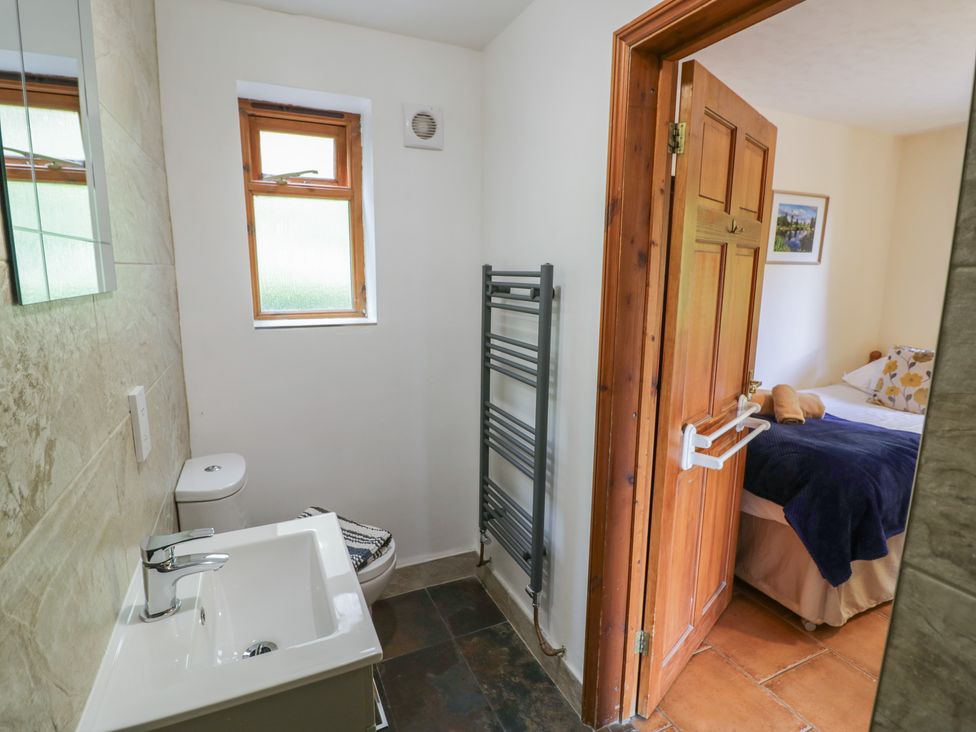 A bathroom with a toilet, sink and towel rack at Woodpecker in Worcester