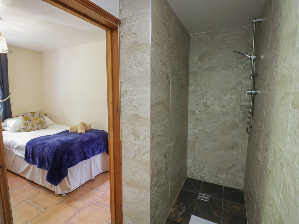 A bedroom with a bed and a shower area at Woodpecker Worcester