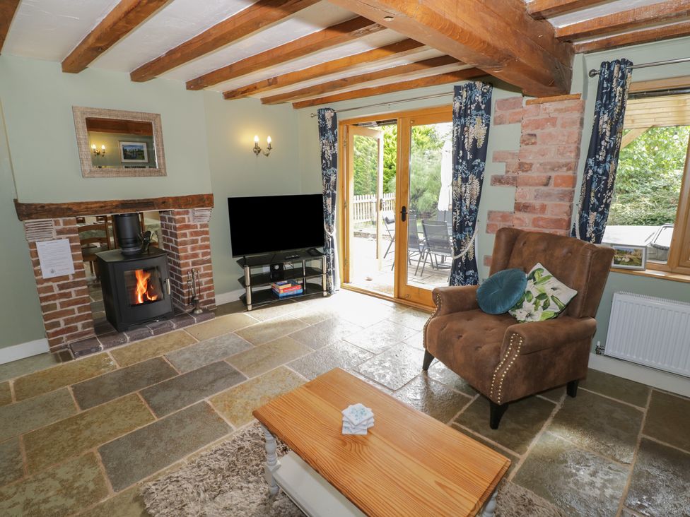 A living room with a fireplace and television at Chaff House in Worcester