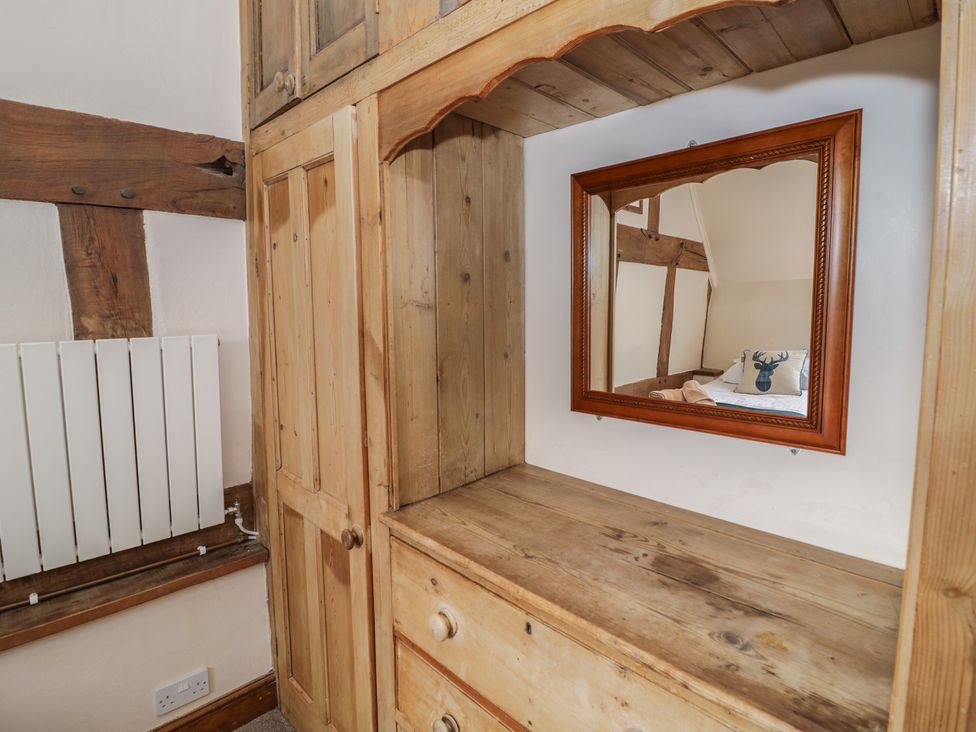 A wooden cabinet with a mirror and drawer in the bedroom at Chaff House Worcester