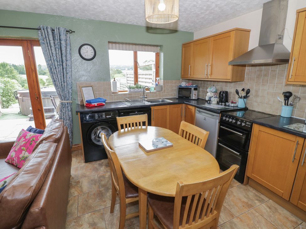 A kitchen with wooden cabinets and dining table at Pippin in Worcester