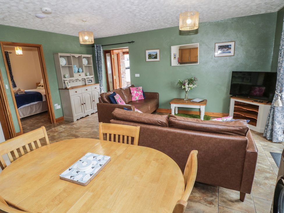A living room with brown sofa and wooden table at Pippin in Worcester
