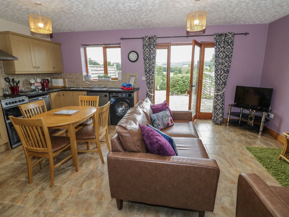 A living room with a kitchen and dining area at Russet in Worcester