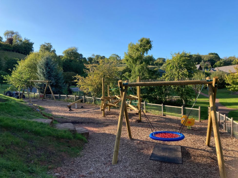 A playground with swings and trees at Bramley in Worcester