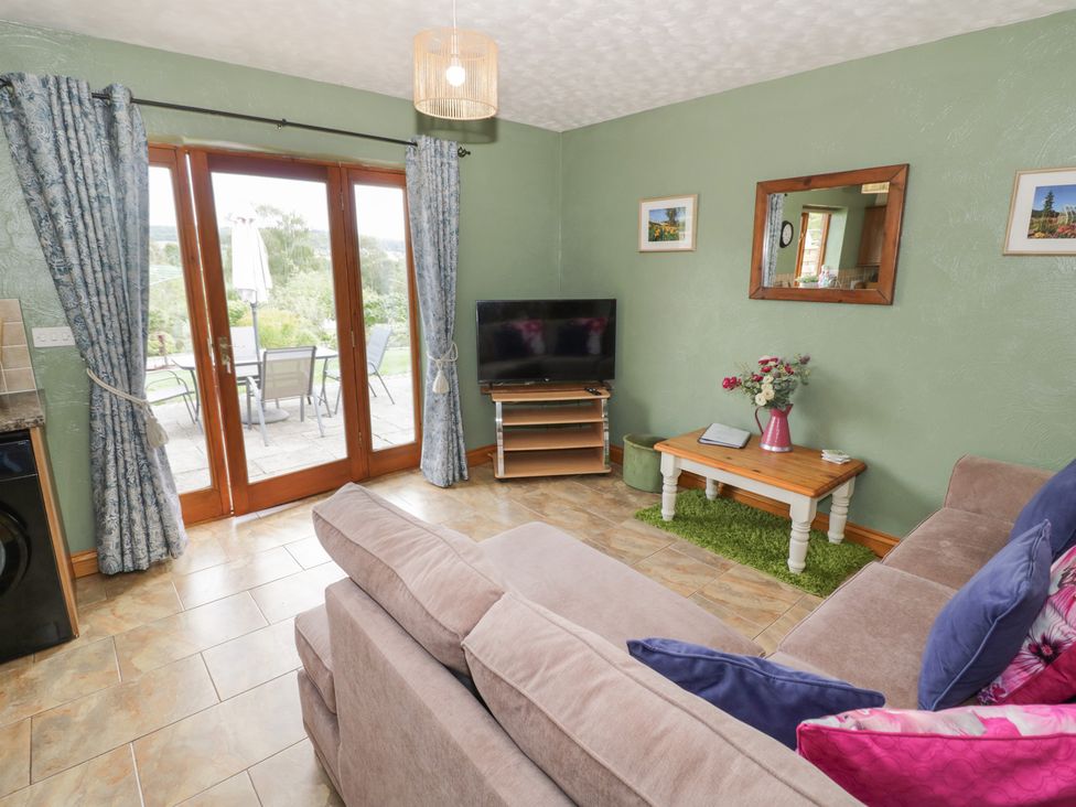A living room with a sofa and a TV at Bramley in Worcester