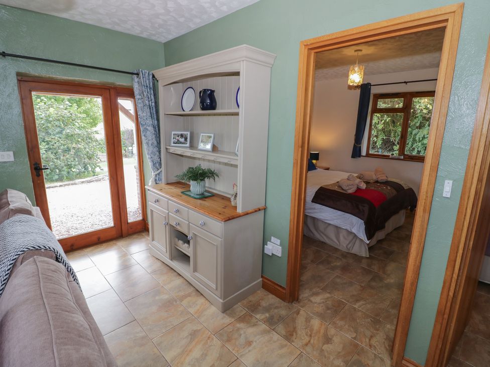 A living room with a shelf and sliding door at Bramley in Worcester
