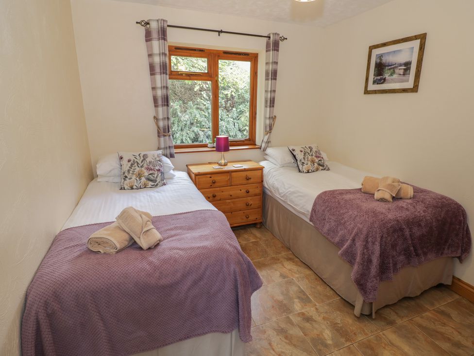 A bedroom with two single beds and a bedside table at Bramley in Worcester