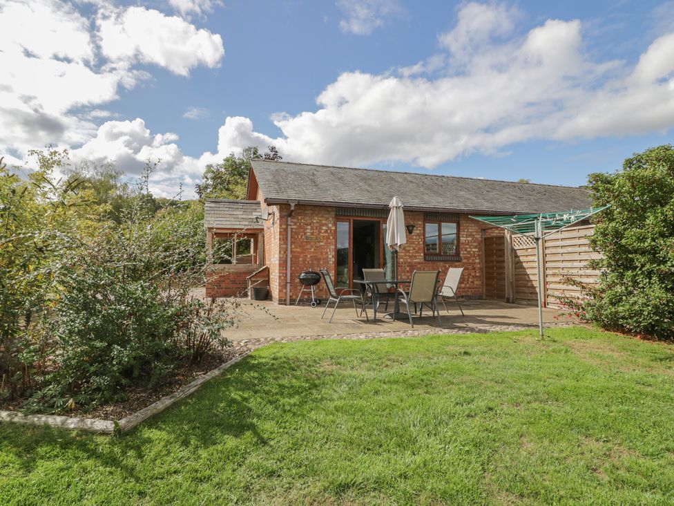 A garden with a patio and table at Bramley in Worcester