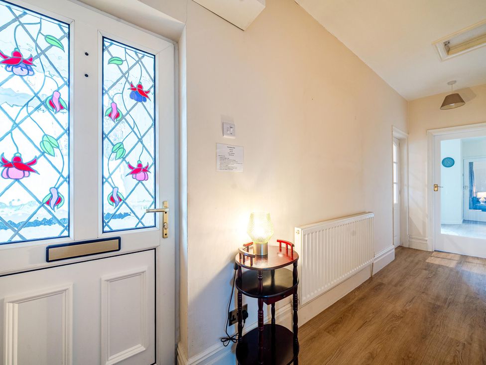 A hallway with a stained glass door and a side table lamp at Waltergarth in Horton-In-Ribblesdale