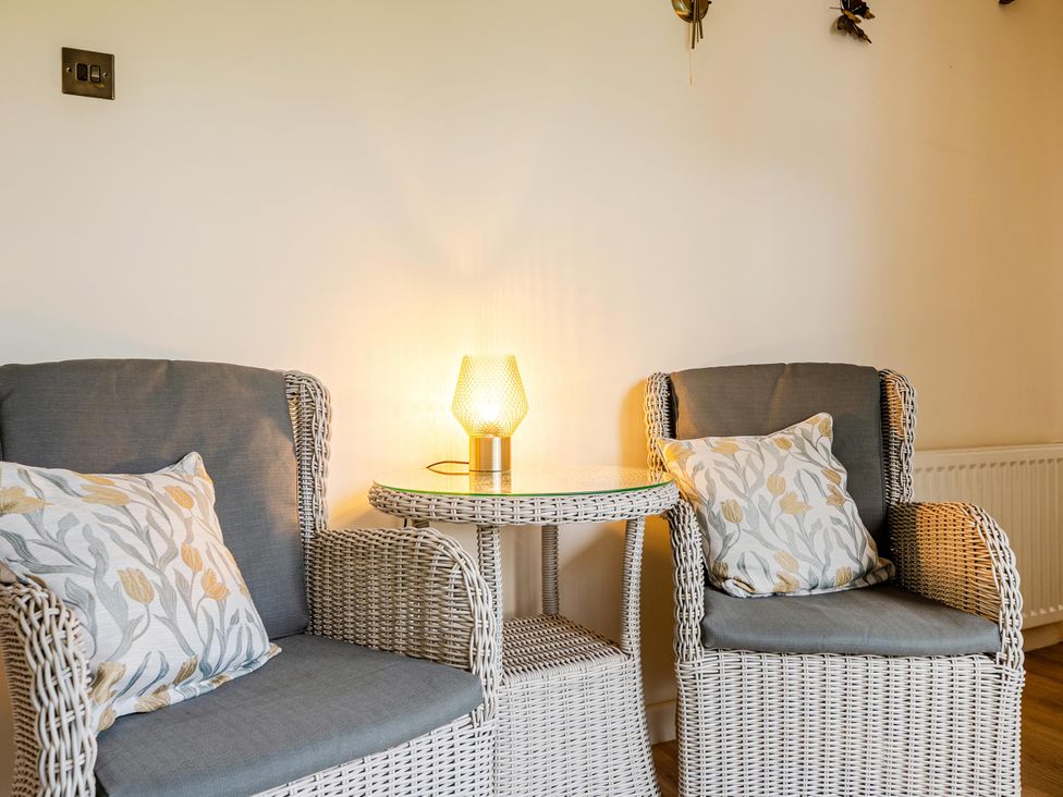 A sitting room with two chairs and a lamp at Waltergarth in Horton-In-Ribblesdale