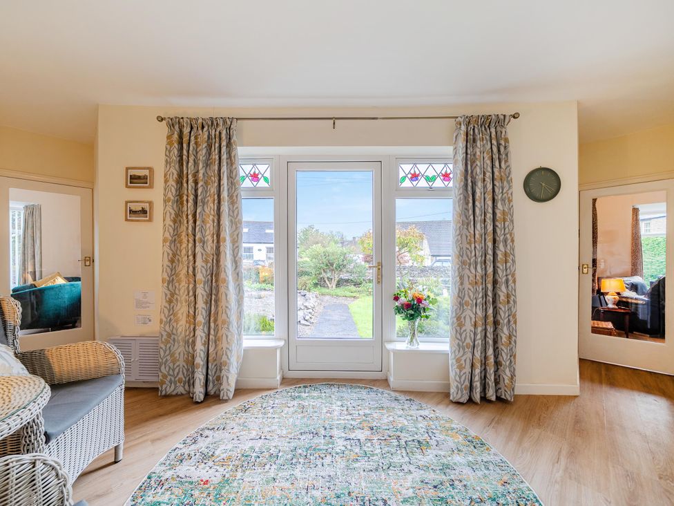 A living room with a glass door and rug at Waltergarth in Horton-In-Ribblesdale