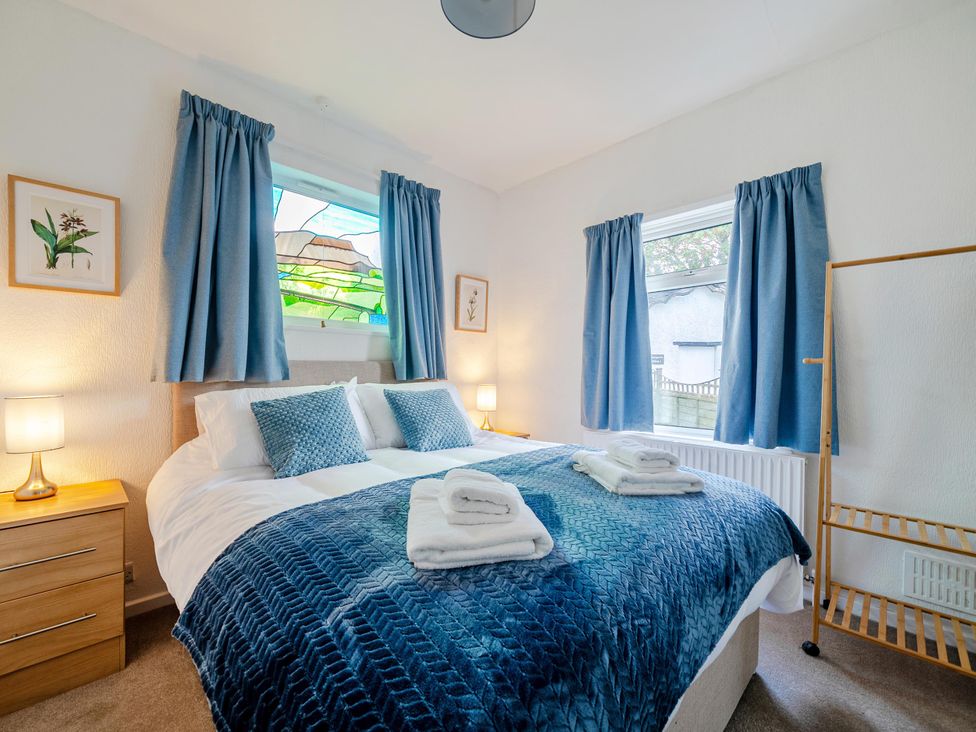 A bedroom with a bed and stained glass window at Waltergarth in Horton-In-Ribblesdale